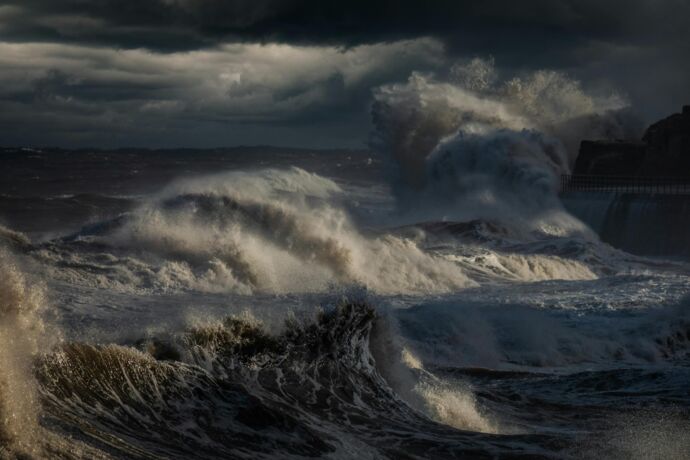 Waves crashing against a shore, by Ray Bilcliff.jpg